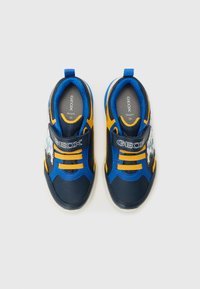 Blaue und gelbe Sneakers mit Gummisohle, Klettverschluss, Netzakzenten und einem grafischen Design an der Seite. Größe 28.