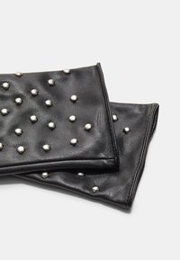 Schwarze Leder-Clutch-Taschen mit silbernen Nieten, die eine strukturierte Oberfläche und eine rechteckige Form aufweisen, leicht übereinander gestapelt.