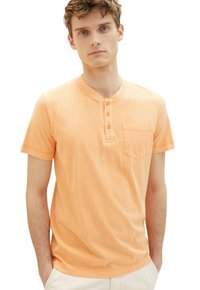 Kortærmet henley-shirt i lyse orange, med fem knapper, brystlomme og en glat bomuldsstruktur. Enkelt design.