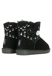 Botas de tobillo de ante negro con forro de piel, recortes decorativos, botón metálico redondo y suela de goma texturizada.