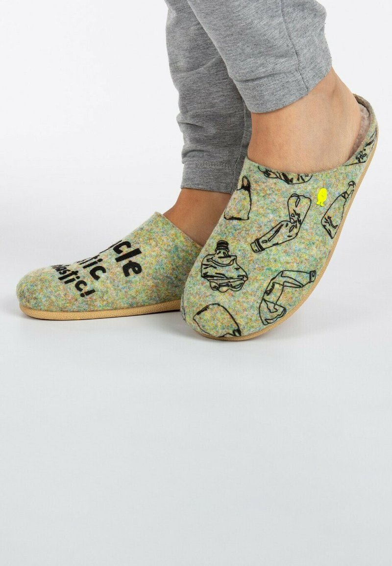 Zapatillas de fieltro con una textura multicolor, que presentan dibujos en línea negra de botellas de plástico y un acento amarillo sobre un fondo verde.