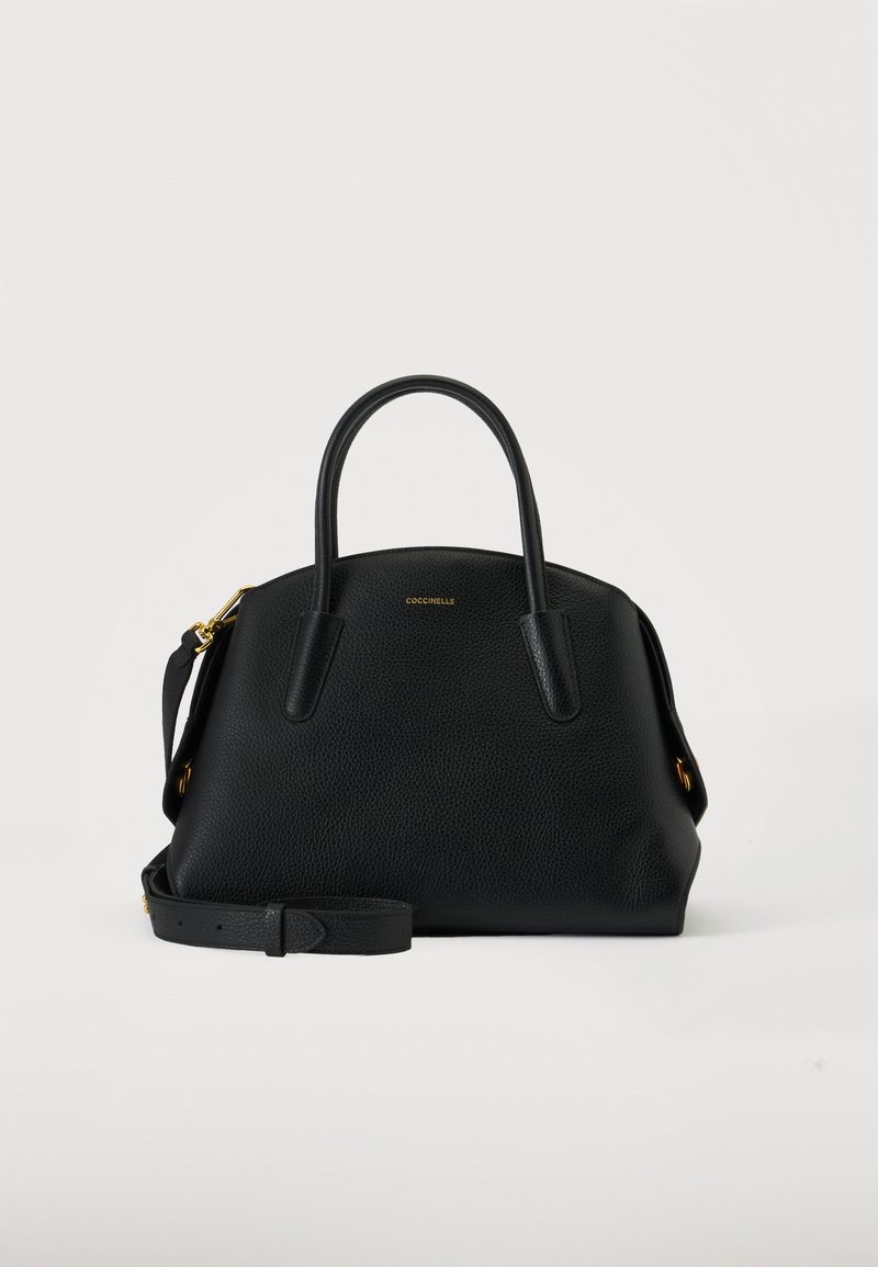 Sac à main en cuir noir avec deux poignées arrondies, ferrures dorées, une bandoulière amovible et un petit texte doré du nom de la marque à l'avant.