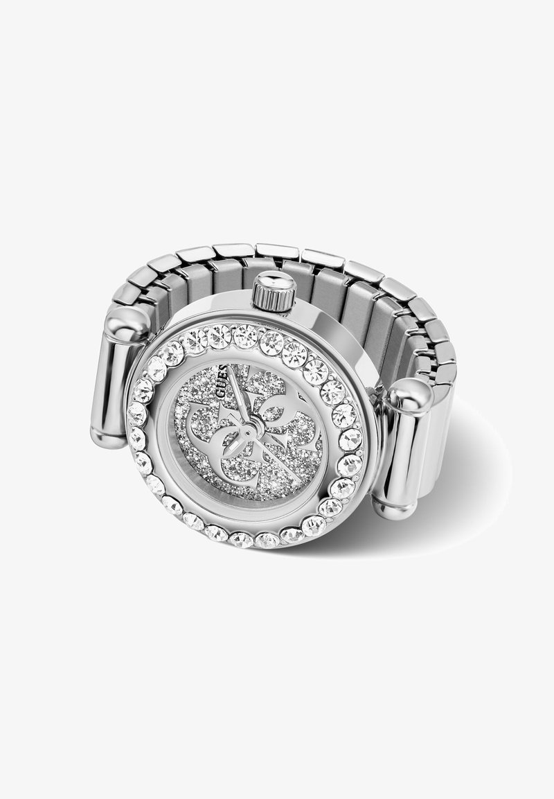 Montre-bracelet pour femme en argent avec bracelet métallique extensible, lunette sertie de cristaux, cadran scintillant et logo décoratif sur le cadran.