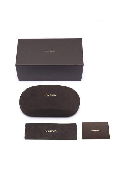 Cutie texturată maro cu logo-ul auriu "TOM FORD". Include o carcasă ovală asortată, o cârpă de curățare și un cartonaș informativ. Toate articolele sunt de culoare maro.