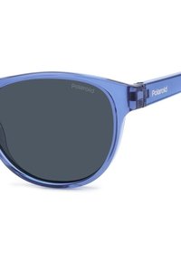 Occhiali da sole blu traslucidi con lenti scure, forma a cat-eye e marchio Polaroid sul braccio. Texture liscia con hardware minimale.