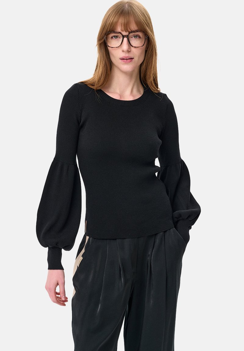 Czarny prążkowany sweter z bufkami, okrągłym dekoltem i dopasowanym tułowiem. Połączony z plisowanymi czarnymi spodniami, z subtelnym detalem w postaci logo.