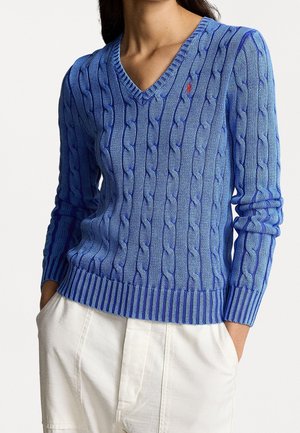 Blue cable-knit sweater with a V-neck, featuring ribbed cuffs and hem. Notable small red logo on the chest. Soft texture and fitted design.