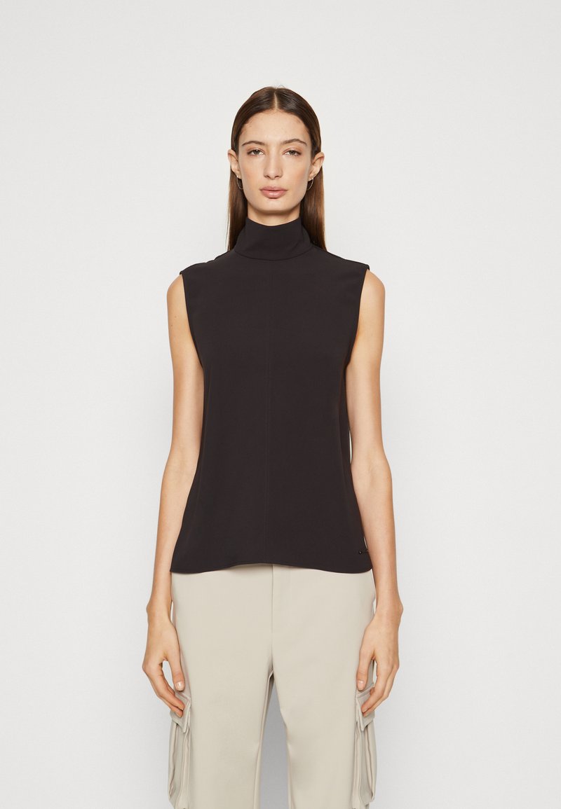 Top senza maniche nero con collo alto, texture liscia e silhouette aderente. Presenta un dettaglio logo discreto nella parte inferiore.