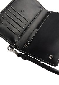 Czarny skórzany portfel z widocznym szyciem. Posiada wiele kieszonek na karty, przegrodę zapinaną na zamek oraz odczepiany pasek. Akcenty w srebrnym kolorze.