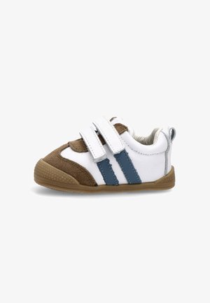 Zapatilla para niño pequeño en blanco y marrón con rayas azules, que cuenta con dos correas de Velcro, una punta redondeada y una suela de goma texturizada.