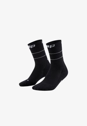 Schwarze Socken mit einer gerippten Textur, die zwei graue horizontale Streifen nahe der Oberkante und ein Markenlogo am Bund aufweisen. Mittlere Schafthöhe.