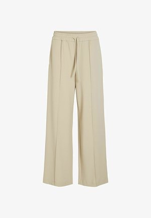 Pantaloni bej, cu picioare largi, realizați dintr-un material moale, având un brâu elastic cu șnur și două pliuri frontale.