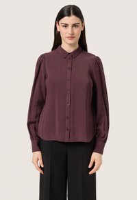 Burgundy button-up shirt with a collar, long puff sleeves, and a relaxed fit. Made from a smooth fabric with a subtle sheen.