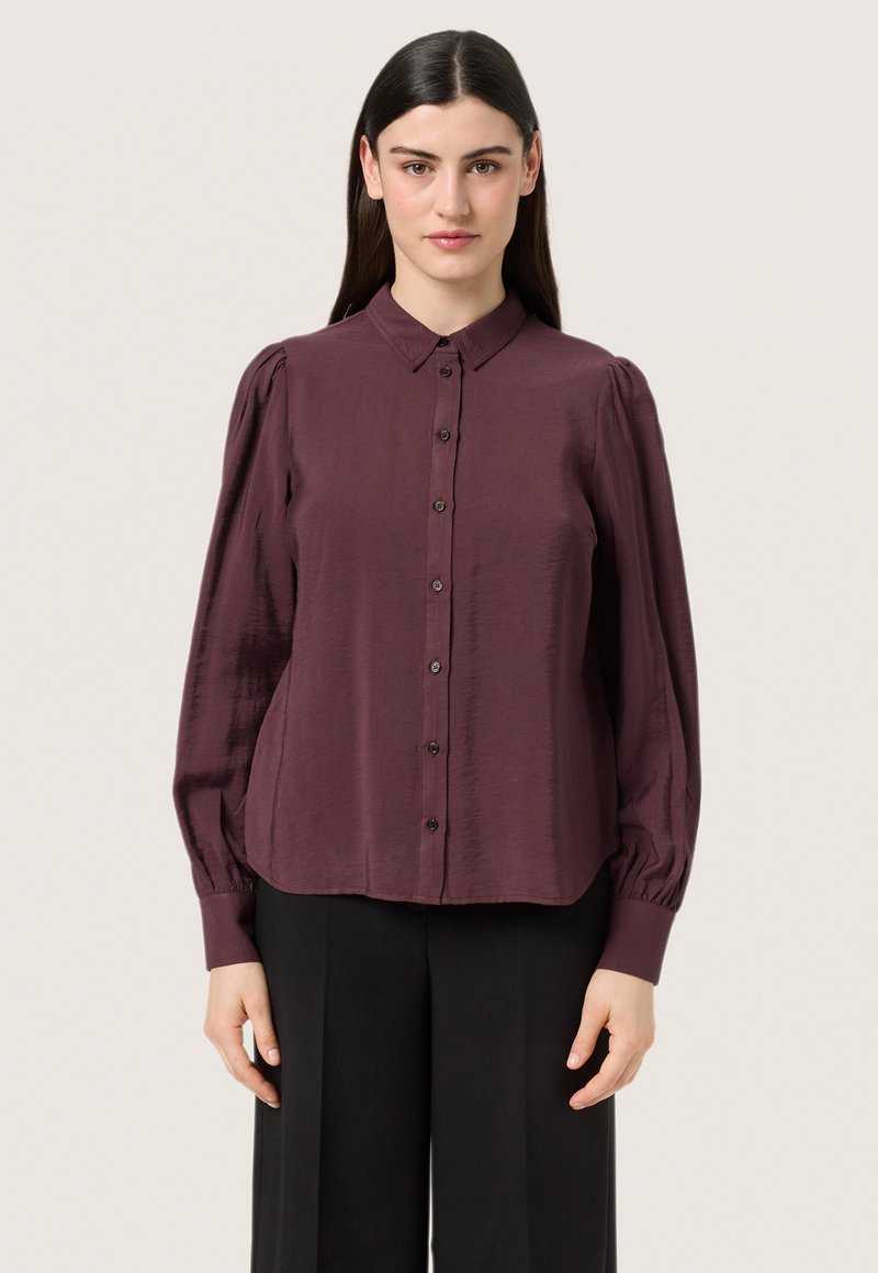 Burgundy button-up shirt with a collar, long puff sleeves, and a relaxed fit. Made from a smooth fabric with a subtle sheen.