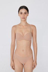 Kobieta stojąca przodem, nosząca beżowy bardotka z odpinanymi ramiączkami oraz pasujące bikini, na tle białego tła.