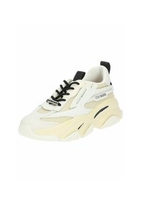 Sneaker blanche épaisse avec des sections en maille, lacets noirs et une marque discrète. Elle présente une semelle épaisse et texturée ainsi que des accents beige contrastants.