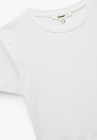 Hvid bomulds t-shirt med rund hals, korte ærmer og en glat tekstur. Mærket synligt indeni halsudskæringen. Størrelse: M.