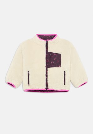 Faux fur jacket in cream with a short collar, pink trim, and a dark purple zippered pocket featuring a floral pattern.