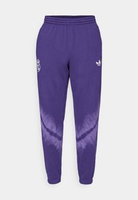 Calças de sudoeste de algodão roxas com um logo branco da Adidas e o emblema do Real Madrid. Apresenta um efeito de dip-dye que transita para um roxo mais claro na parte inferior.