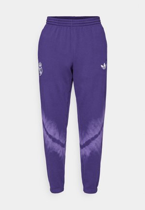 Purple cotton sweatpants with a white Adidas logo and Real Madrid crest. Features a dip-dye effect transitioning to lighter purple at the bottom.