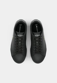 Sneaker nere con lacci, in pelle liscia, con un sottile accento dorato, lacci piatti e suola in gomma testurizzata.