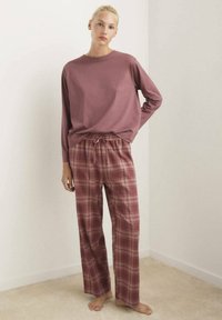 Dlh�ý rukáv, tlmený mauve top v kombinácii s plaid pyžamovými nohavicami v ružovej, červenej a krémovej farbe. Nohavice majú elastický pás a šnúrku.