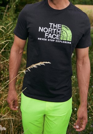 Černé bavlněné tričko s bílým a zeleným grafickým logem "The North Face" a sloganem "Nikdy nepřestávejte prozkoumávat."
