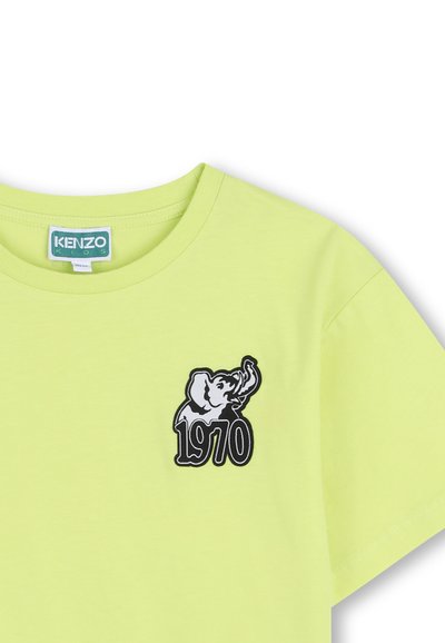 T-shirt enfant vert clair avec un patch éléphant noir et blanc et "1970" imprimé sur la poitrine, étiquette Kenzo Kids à l'intérieur du col.