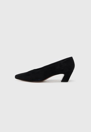 Black suede pump with a pointed toe and contrasting geometric block heel. Smooth texture, minimalist design, suitable for formal wear.