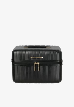 Black hard-shell makeup case with horizontal ridges, double zipper closure, top handle, and a small gold brand label.