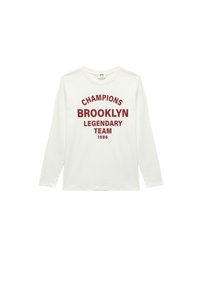 Biała koszulka z długim rękawem wykonana z bawełny, z czerwonym napisem: "CHAMPIONS BROOKLYN LEGENDARY TEAM 1986" w pogrubionym, łukowatym wzorze.