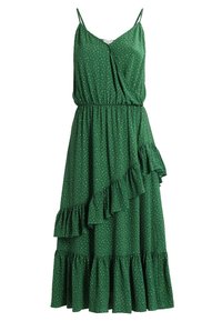 Green dress with a fitted bodice, adjustable spaghetti straps, ruffled hem, and white polka dots. Lightweight fabric, mid-length design.