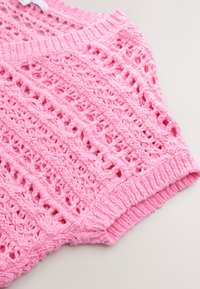 Pink knitted top featuring an openwork crochet design, ribbed hem, and wide neckline. Soft texture with a lightweight, breathable feel.