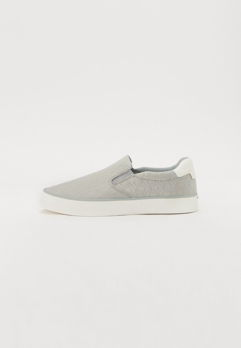Gray slip-on shoes with a textured pattern, white sole, and elastic side inserts for easy wear. Smooth finish and round toe design.