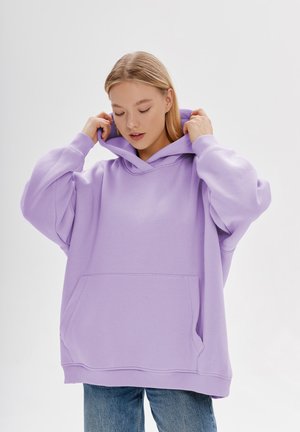 Oversized lavendelkleurige hoodie met een voorzak, een capuchon met trekkoord en geribbelde cuffs. Zachte stof met een gladde textuur.