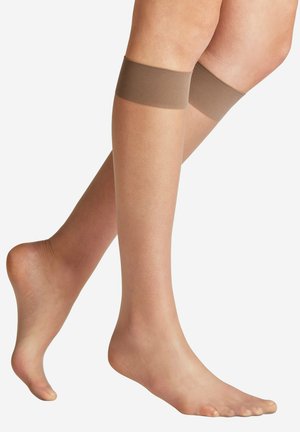 Legs wearing sheer nude knee-high stockings with reinforced tops, shown against a plain white background.