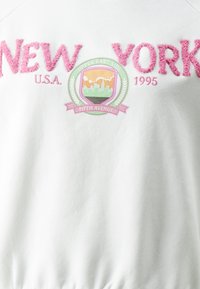 Bílá mikina se šedou fuzzy výšivkou "NEW YORK", barevným emblémem z detaily "UPPER EAST SIDE", "1995" a "FIFTH AVENUE".