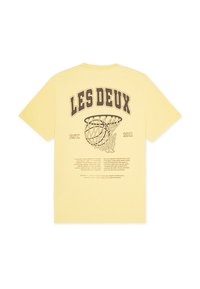 Κίτρινο βαμβακερό μπλουζάκι με μεγάλο καφέ γραφικό ενός μπασκετικού στεφανιού και κείμενο. Λαιμόκοψ η με rib, κοντά μανίκια. Καθημερινή, άνετη εφαρμογή.