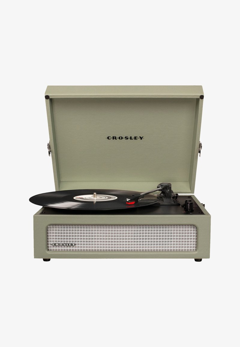 Tocadiscos Crosley en verde claro con un exterior texturizado, superficie de reproducción negra y un disco de vinilo negro visible. Presenta herrajes metálicos.