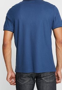 T-shirt bleu marine à manches courtes en coton, avec un design simple, un col rond et un ourlet droit, vu de dos.