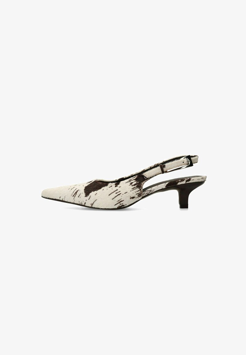 Slingback kittenhiel schoen in wit en bruin gespikkeld patroon, voorzien van een puntige neus en een smalle band met verstelbare gesp.