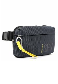 Svart tyg crossbody-väska med en strukturerad yta, gul läderdetalj, silverfärgad hårdvara och ett fack med dragkedja.