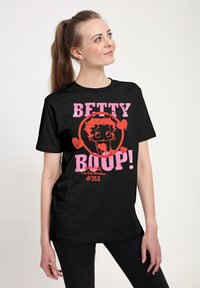 Zwarte katoenen t-shirt met een graphic van een cartoonpersonage en roze en rode tekst met de tekst "BETTY BOOP! Officiële Fanclub Lid #352."