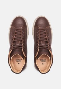Braune Leder-Hochstiefel-Sneaker mit strukturiertem Obermaterial, cremefarbener Gummisohle, tonaler Naht und flachen Schnürsenkeln. Das Innenfutter zeigt den Markennamen.
