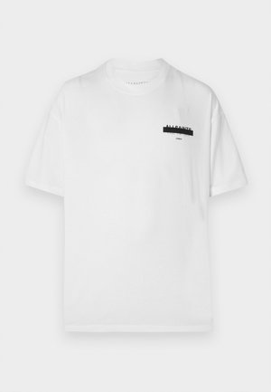 Vit bomullströja med korta ärmar, med en svart tryckt logotyp på vänster bröst och en rak skärning i nederkant.