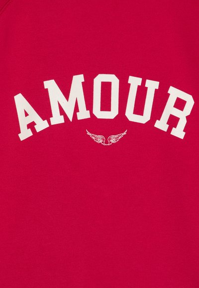 Sudadera roja con la palabra "AMOUR" en letras blancas en negrita, con pequeños gráficos de alas debajo. Material suave de algodón, con cuello redondeado.