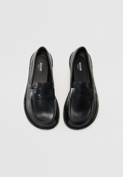 Mustad nahast loaferrid, millel on sile tekstuur, lai rihm ja peen laineline disain esiküljel, tikitud ääred ja lame tall.