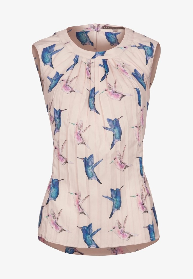 Blouse sans manches rose pâle avec des plissés et un imprimé intégral de colibris bleus et roses, encolure ronde et fermeture zippée au dos.