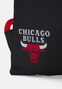 Geantă din material textil negru cu mânere din sfoară roșie, text 'Chicago Bulls' și un logo cu un taur roșu și coarne albe.