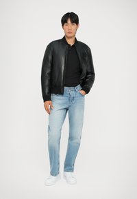 Mustmust nahk bomber-jakk, sobiv must polo, heledad sinised teksad, valged tossud. Sujuv tekstuur, klassikaline disain, lõdvestunud lõige.